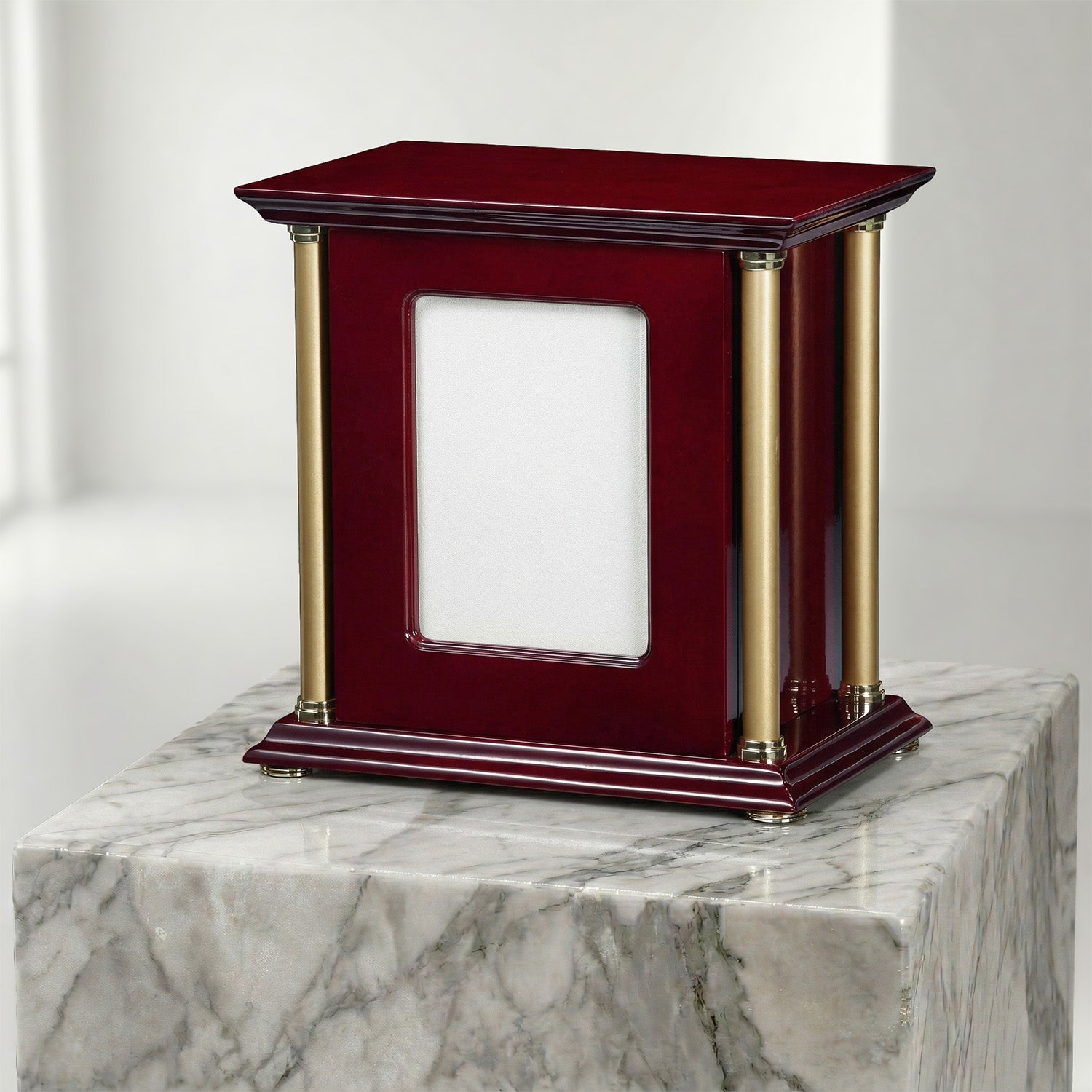 Cherry wood portrait urn with gold accents on a marble surface