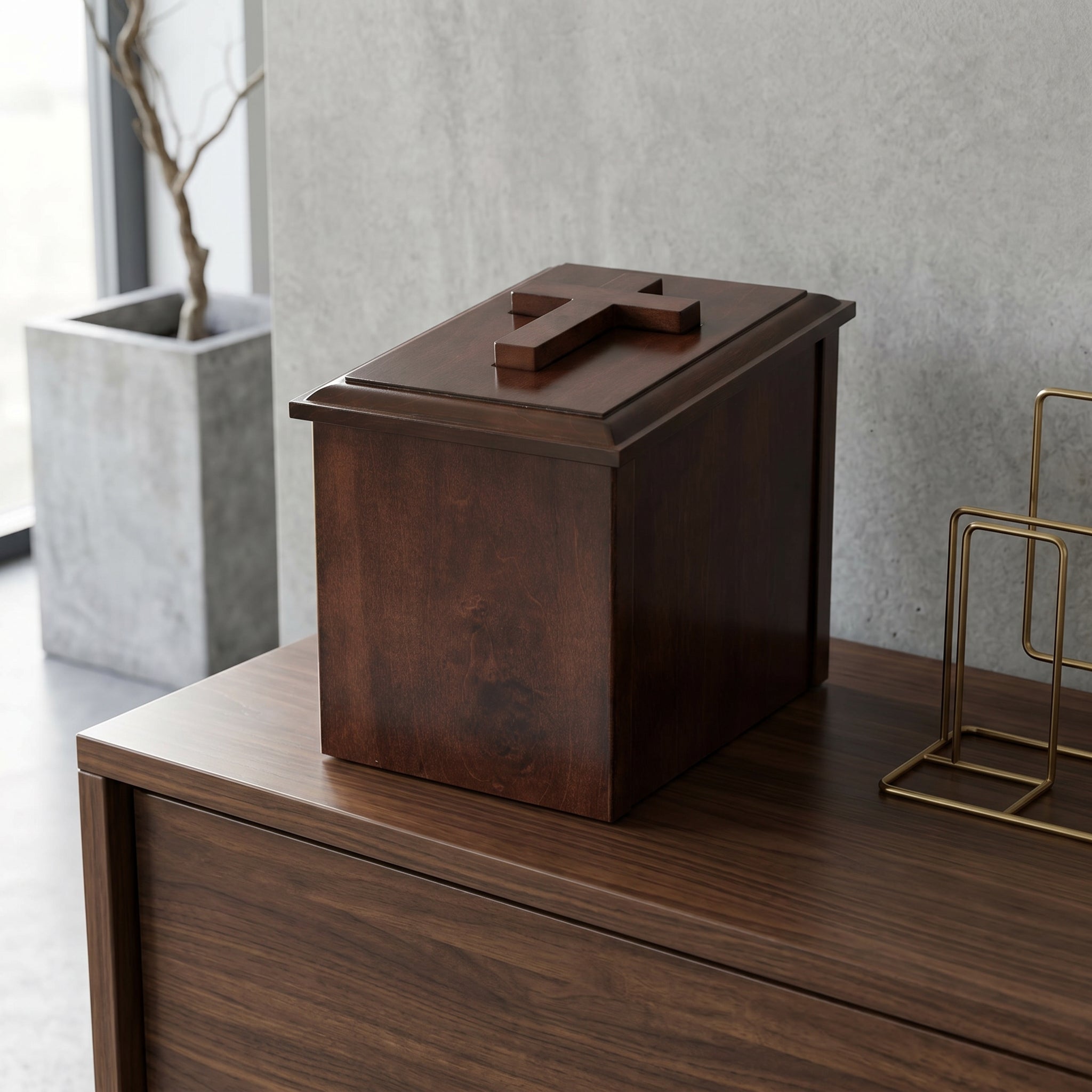 Wooden box urn on a wooden surface with a plant and decorative item in the background