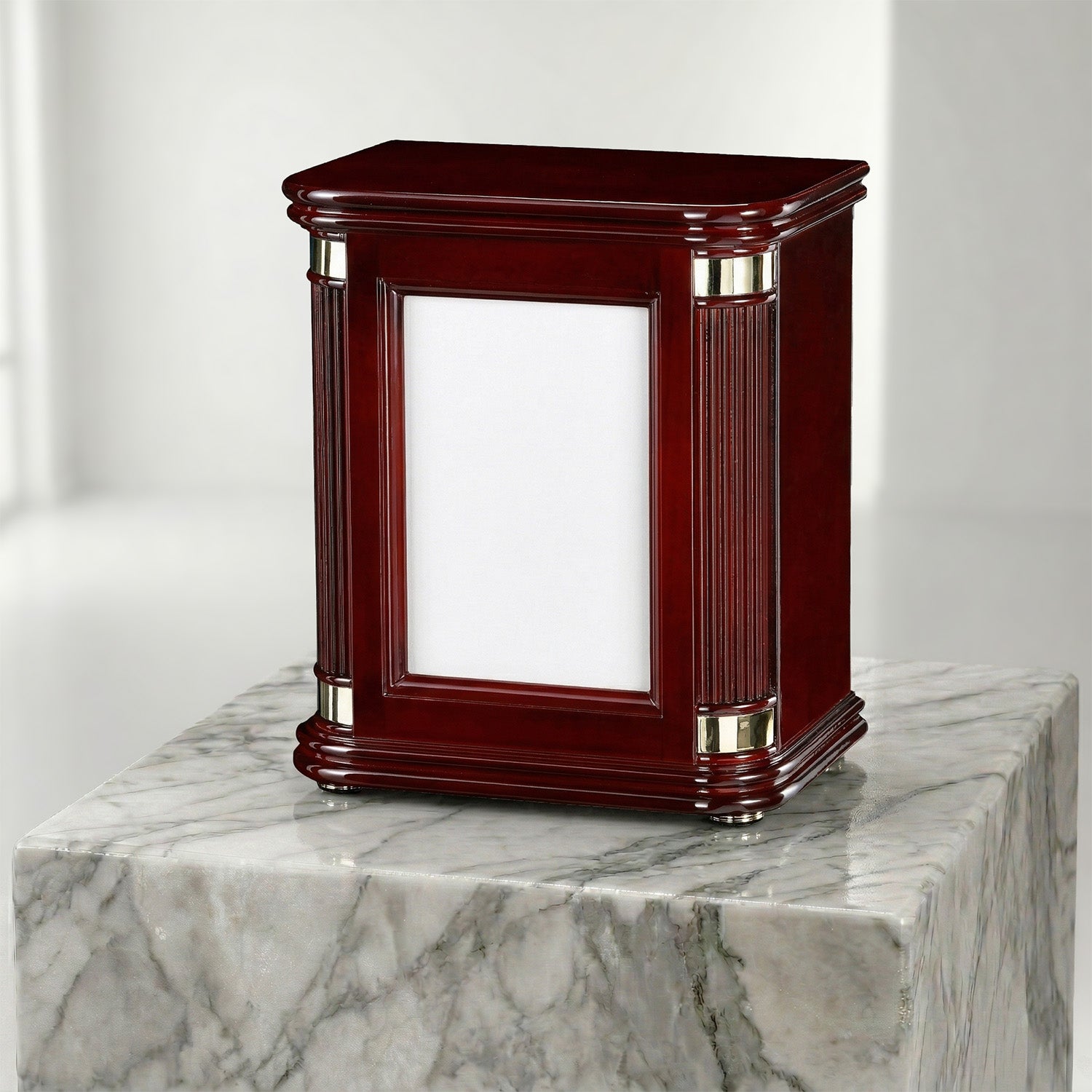 Wooden portrait urn with brass and silver accents on a marble surface