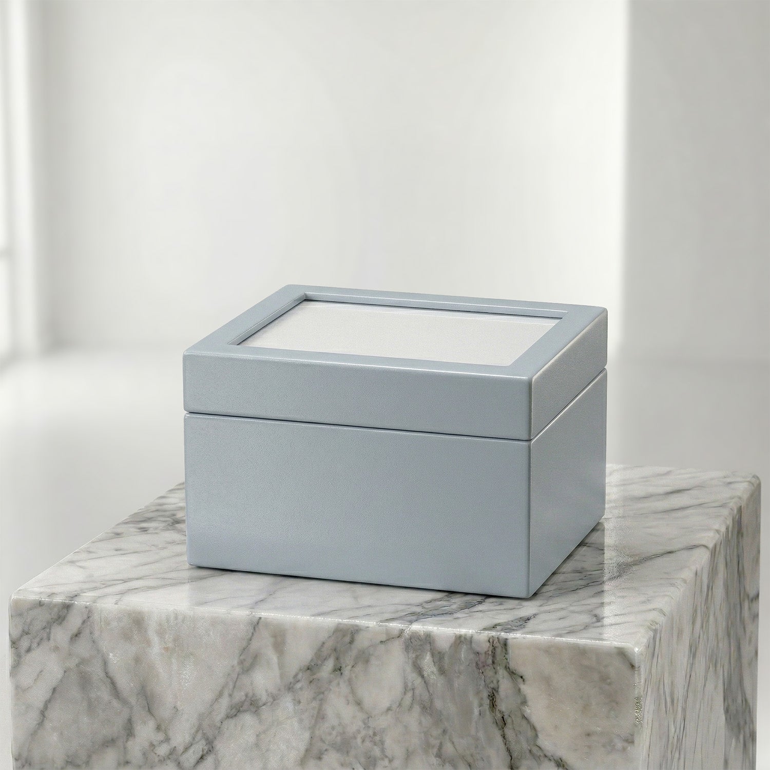 Blue urn box with a clear lid on a marble surface