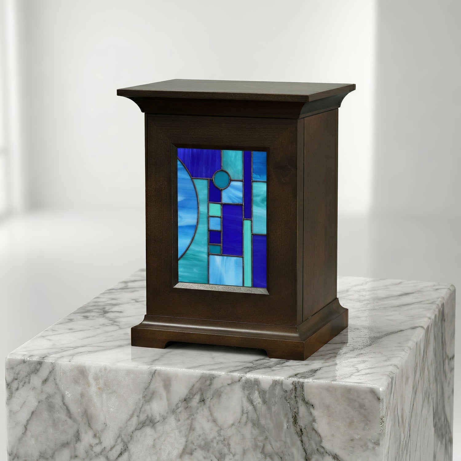 Decorative urn with stained glass panel of a blue shapes on a white background