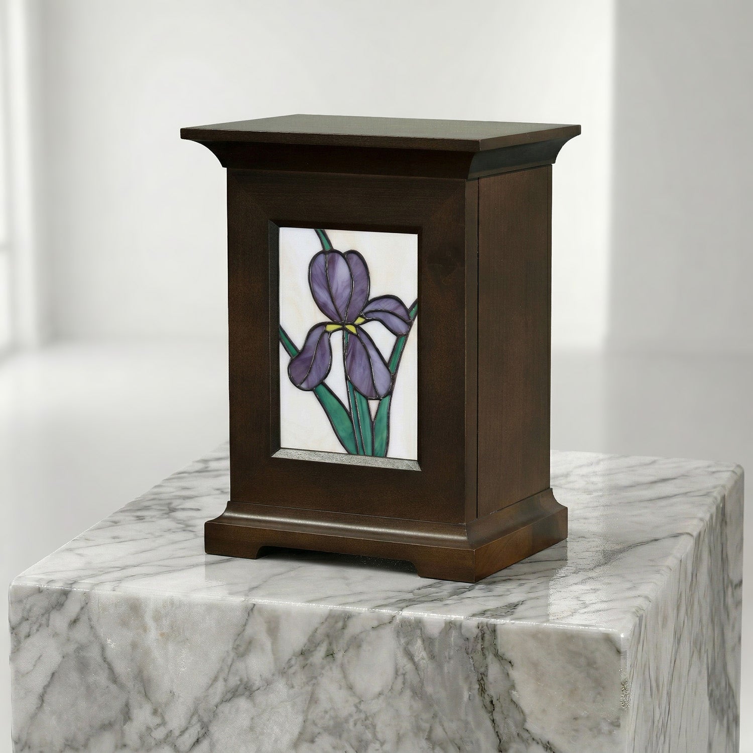 Decorative urn with stained glass panel of a purple iris on a marble surface.