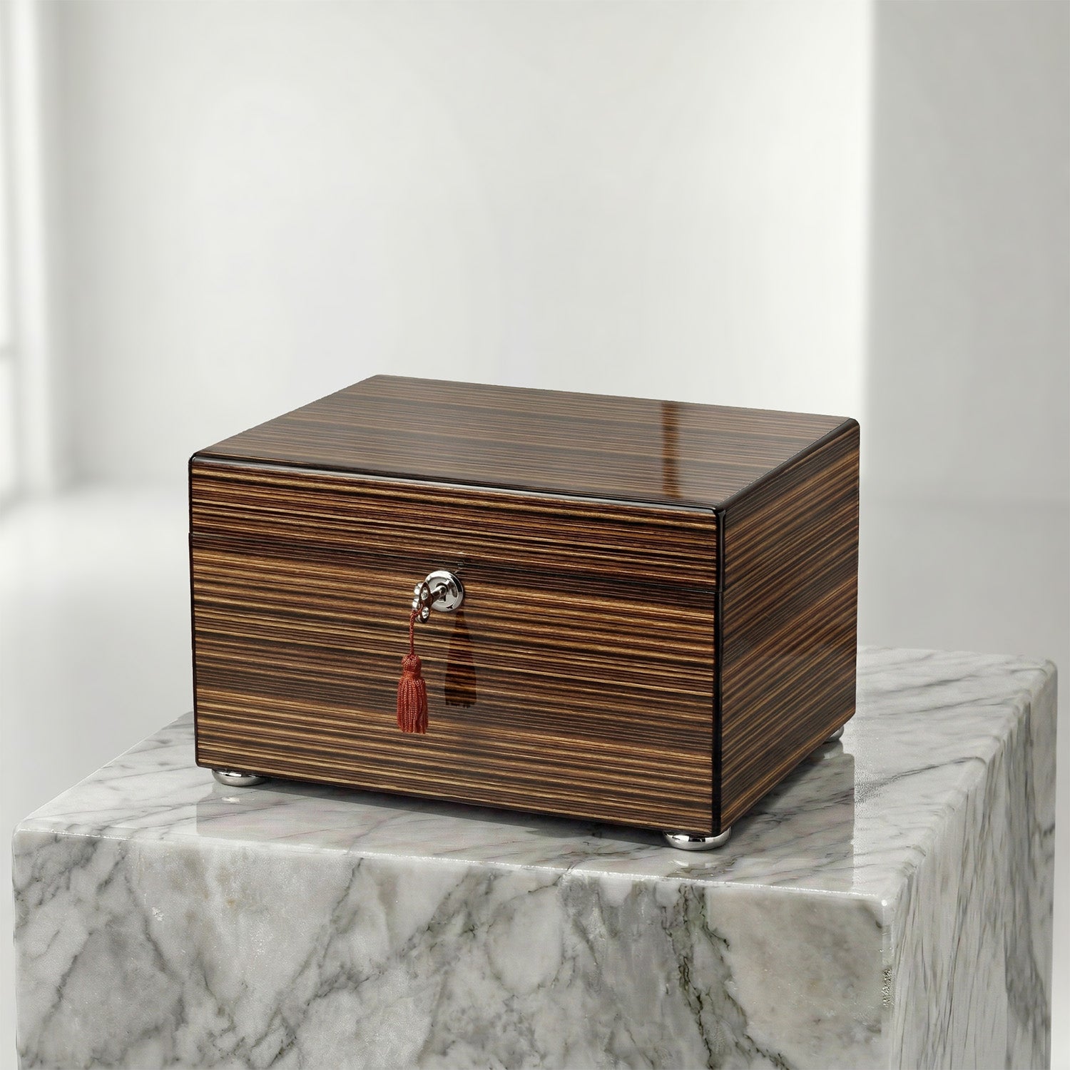 Wooden jewelry box with a tassel on a marble surface