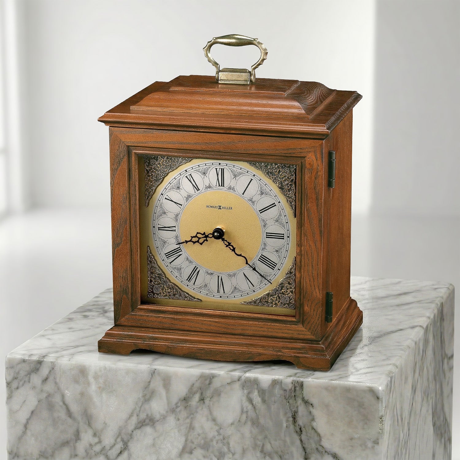 Wooden clock urn with marble face on a marble pedestal against a white background