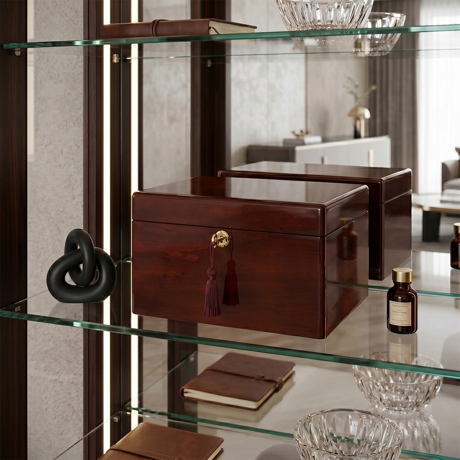 Brown urn box with a gold clasp on a glass shelf with decorative items.