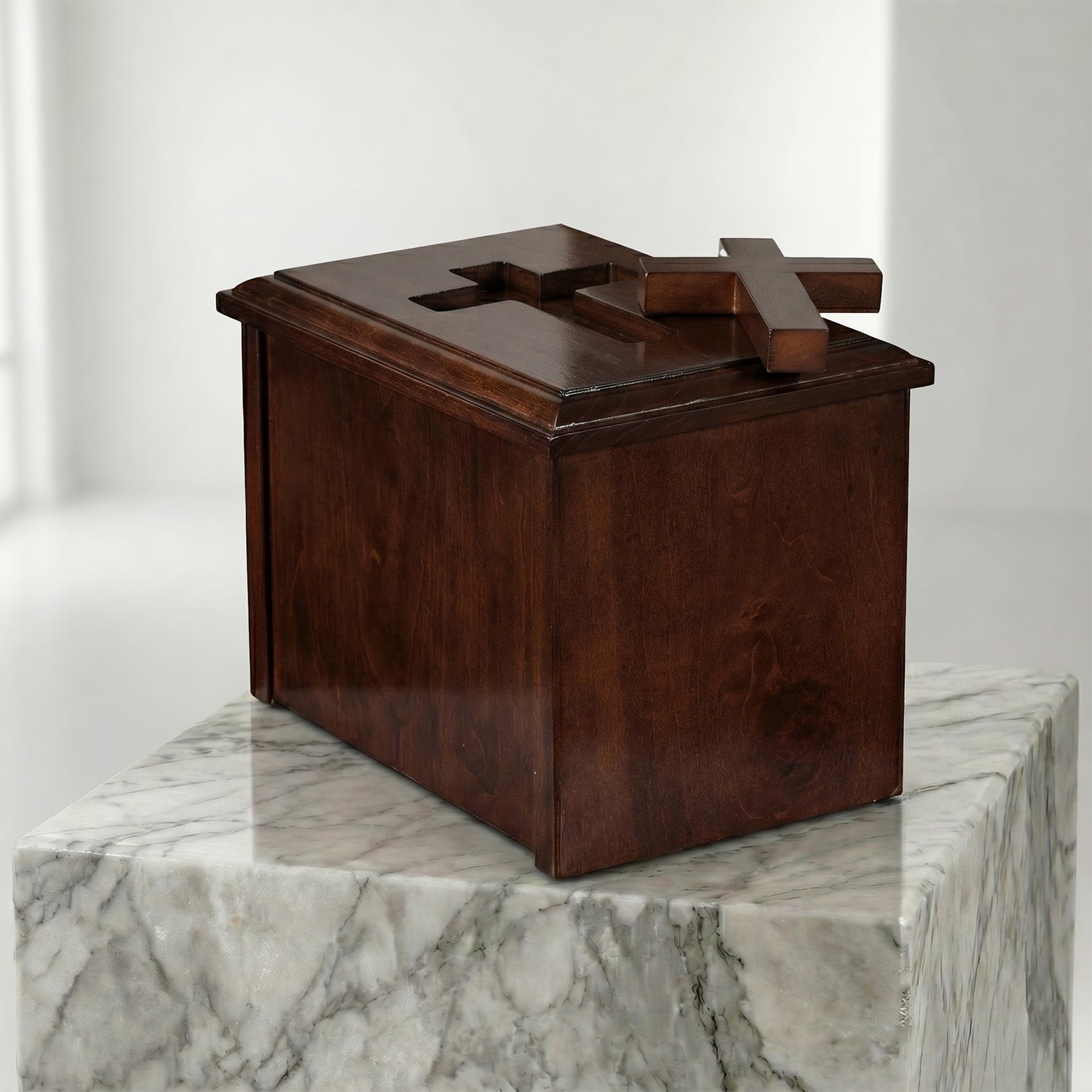 Wooden box with a cross on top, placed on a marble surface.