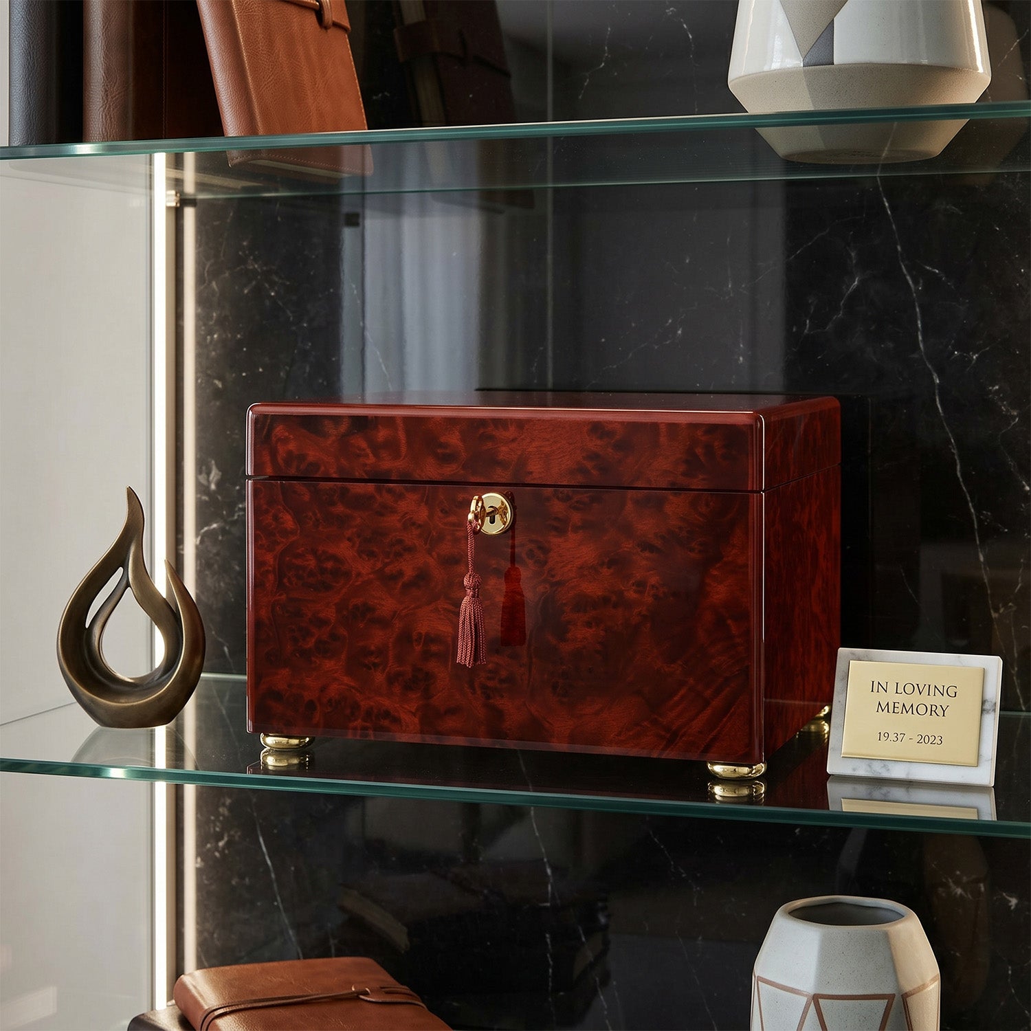 Redwood box urn with gold accents on a glass shelf