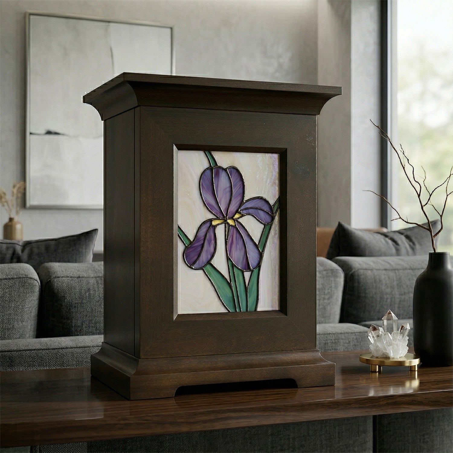 Decorative urn with stained glass panel of a purple iris on a wooden sofa table in a living room setting.